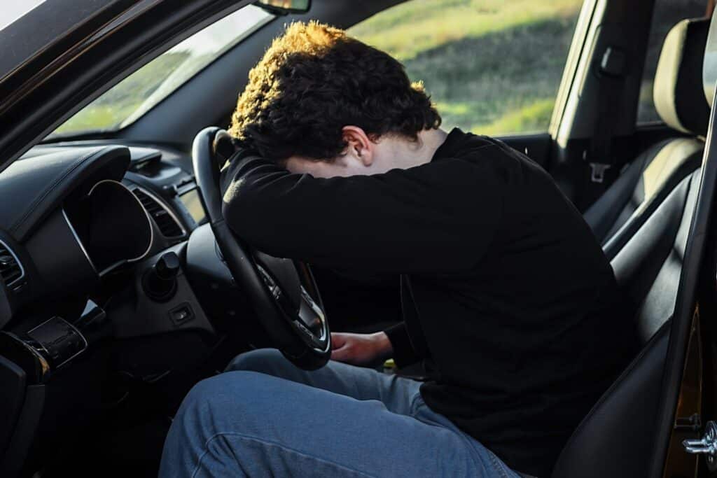 a man with his head in the driver's seat of a car