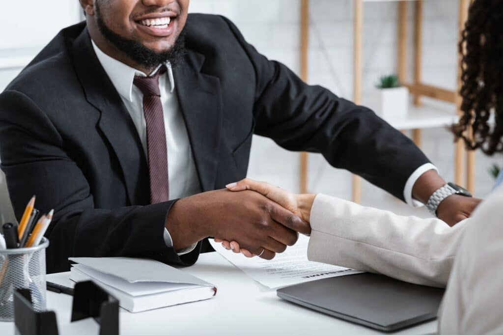 Unrecognizable African American Hiring Manager Shaking Hand Of Vacancy Candidate During Employment